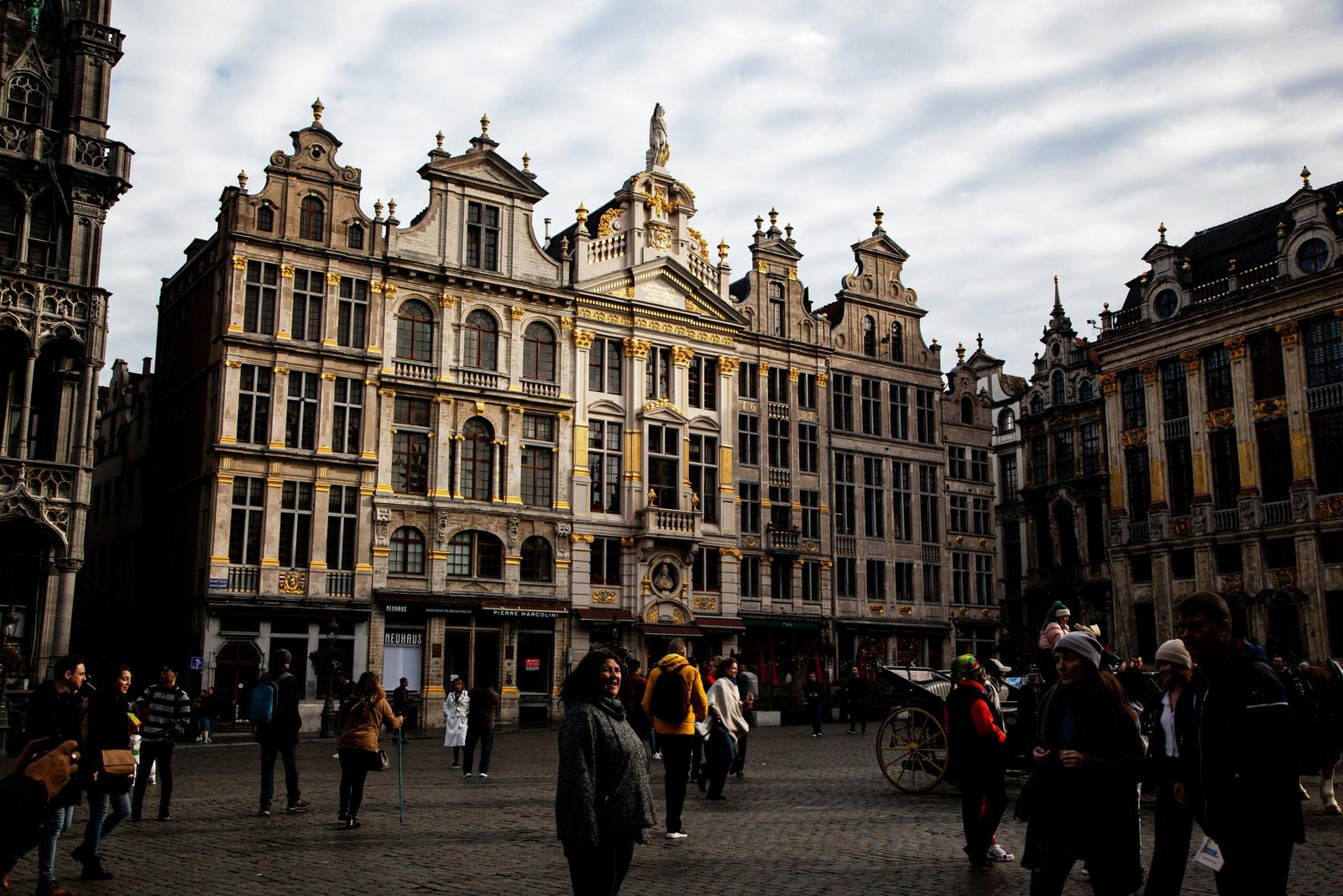 a group of people walking in front of Grand Place